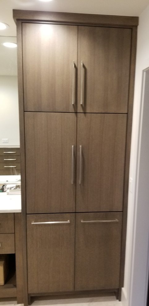 Full-height stained linen tower with slab doors and long vertical pulls