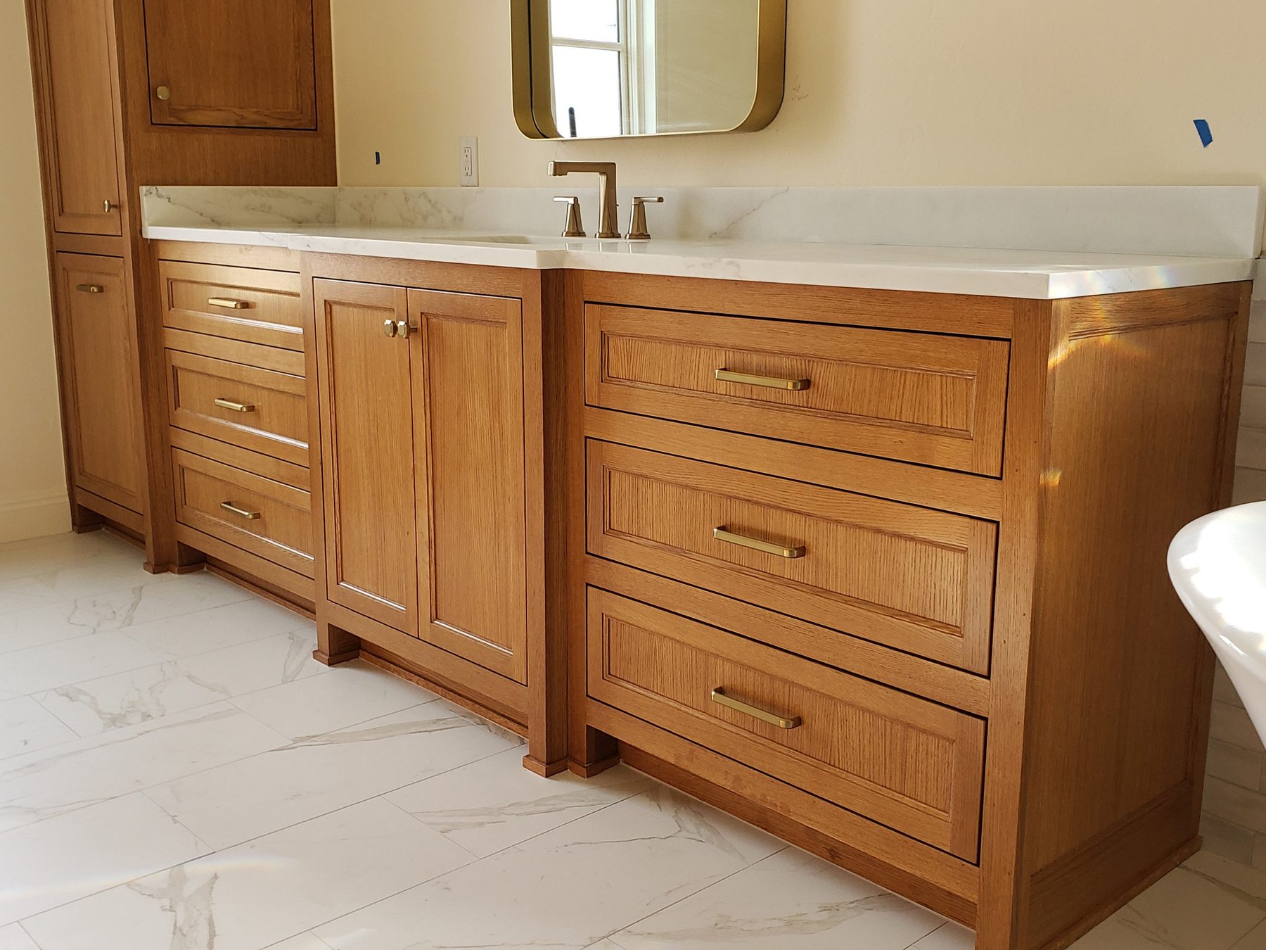 Rift-sawn white oak double vanity with a quartz top and brass hardware